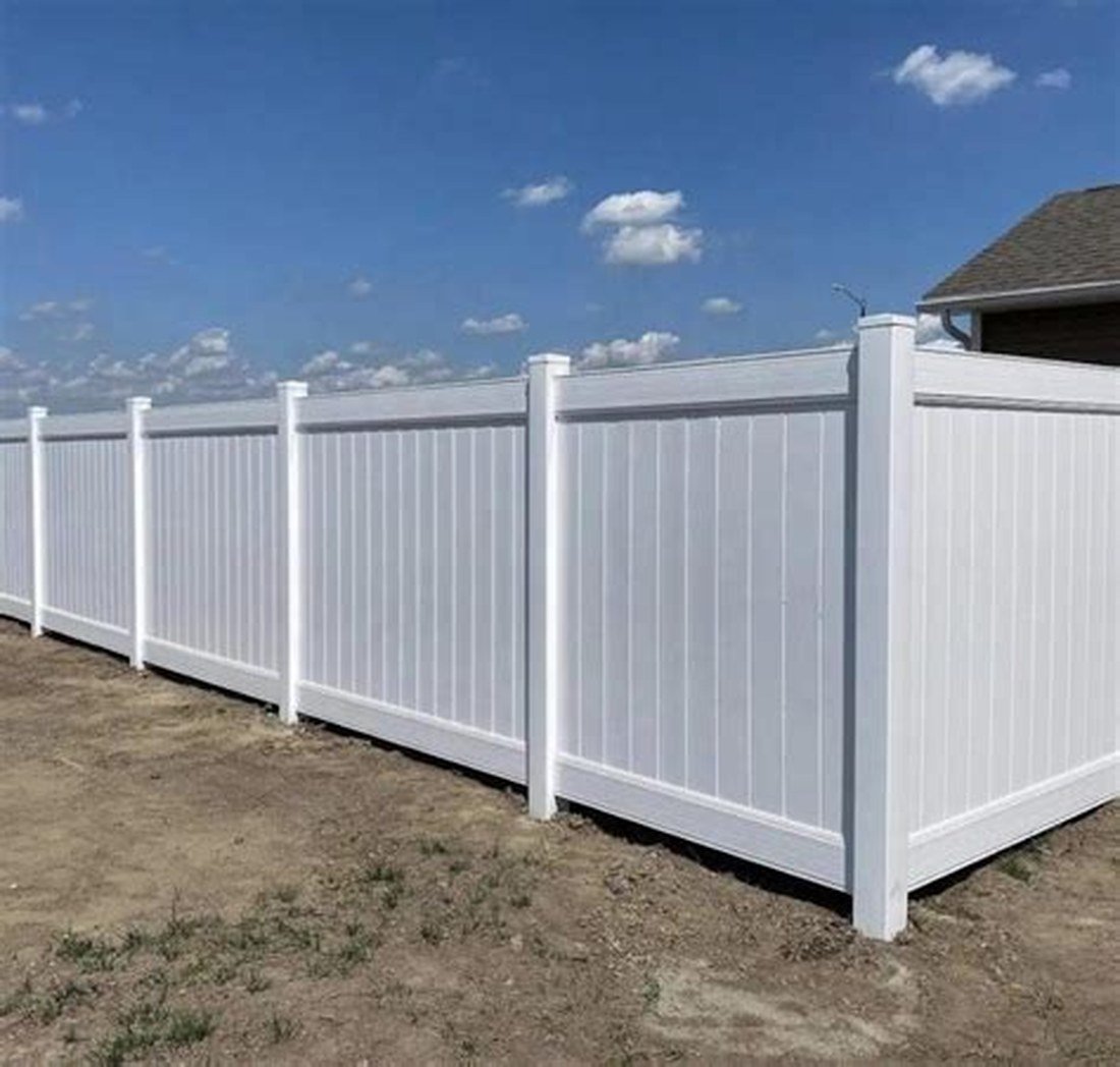 6-foot white PVC privacy fence installed along a backyard
